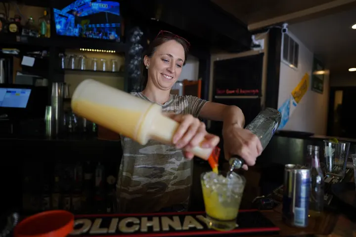 A bartender mixing a drink behind the bar