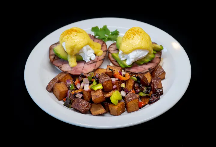 Emerald Benedicts — poached eggs and grilled ham on English muffin with hollandaise