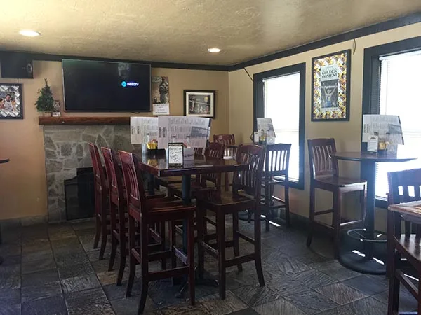 The dining room with flatscreen TVs and the stone fireplace
