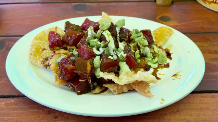 Tuna poke nachos on fried wonton chips with avocado and wasabi